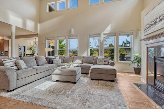580 Eagle Nest Ct, Golden, CO 80401 - living room with wood finished floors, a premium fireplace, a high ceiling, and baseboards