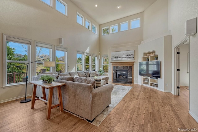580 Eagle Nest Ct, Golden, CO 80401 - living area with a towering ceiling, wood finished floors, a fireplace with flush hearth, baseboards, and recessed lighting