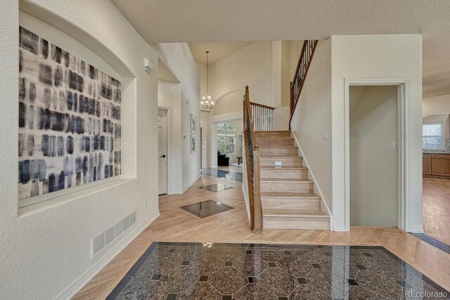 580 Eagle Nest Ct, Golden, CO 80401 - foyer featuring stairway, baseboards, a chandelier, plenty of natural light, and a high ceiling