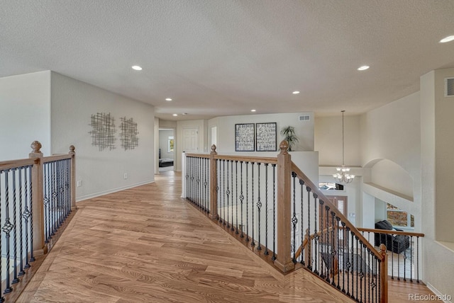 580 Eagle Nest Ct, Golden, CO 80401 - corridor with a chandelier, light wood finished floors, recessed lighting, a textured ceiling, and baseboards