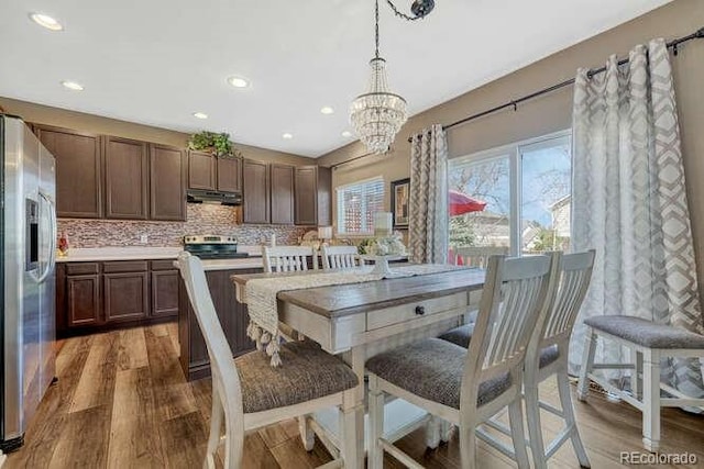 18655 E Garden Pl, Aurora, CO 80015 - dining space featuring wood finished floors, a chandelier, and recessed lighting