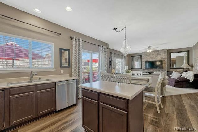 18655 E Garden Pl, Aurora, CO 80015 - kitchen with dishwasher, a sink, open floor plan, light wood finished floors, and a chandelier