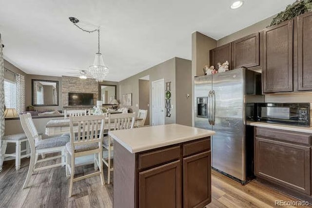 18655 E Garden Pl, Aurora, CO 80015 - kitchen with stainless steel refrigerator with ice dispenser, black microwave, light wood finished floors, a chandelier, and light countertops