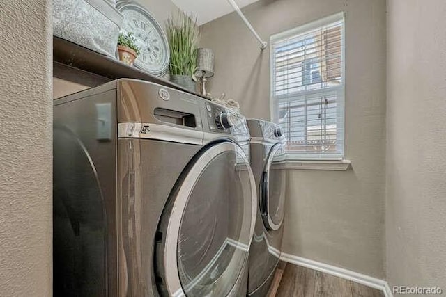18655 E Garden Pl, Aurora, CO 80015 - laundry area with washing machine and dryer, wood finished floors, plenty of natural light, and baseboards