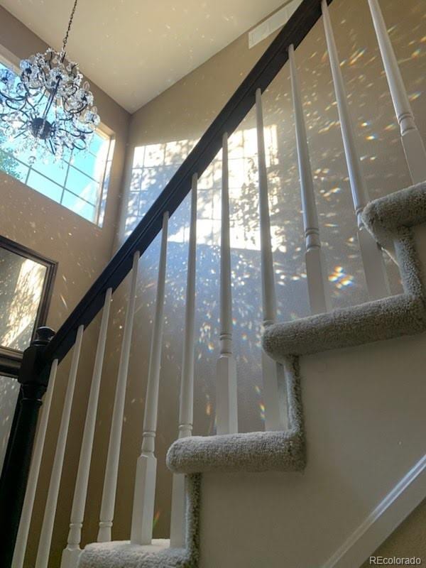18655 E Garden Pl, Aurora, CO 80015 - staircase with a chandelier