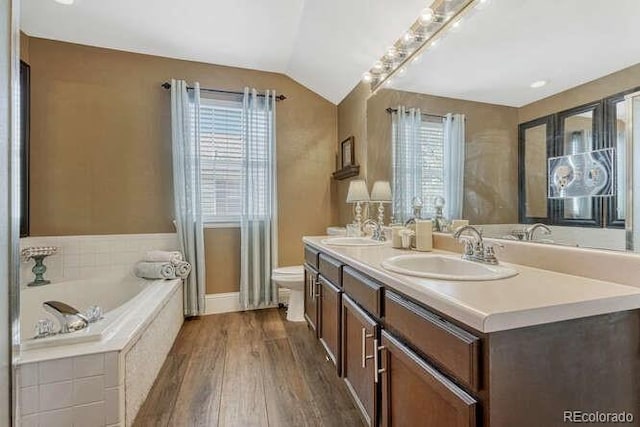18655 E Garden Pl, Aurora, CO 80015 - full bath with double vanity, a garden tub, wood finished floors, lofted ceiling, and toilet