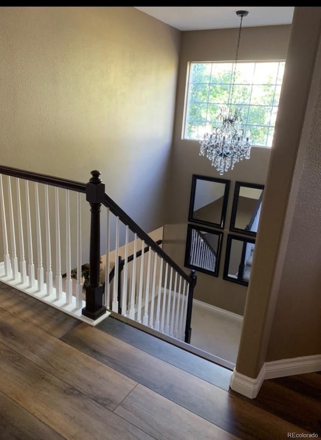 18655 E Garden Pl, Aurora, CO 80015 - stairs featuring a chandelier, wood finished floors, and baseboards