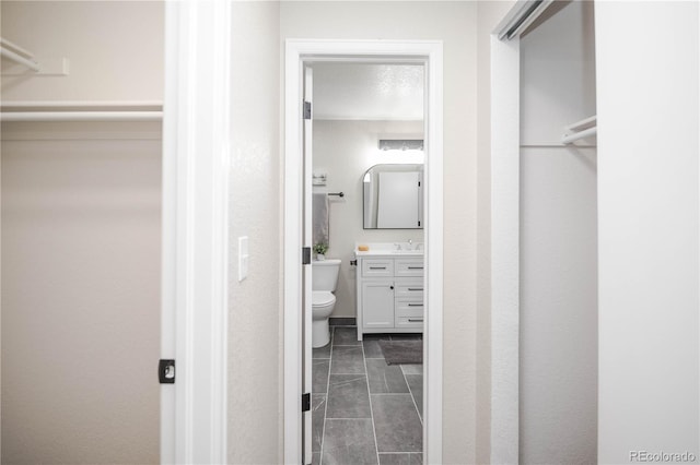 interior space with tile patterned floors, vanity, a textured ceiling, and toilet