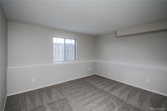 unfurnished room with carpet flooring and a textured ceiling