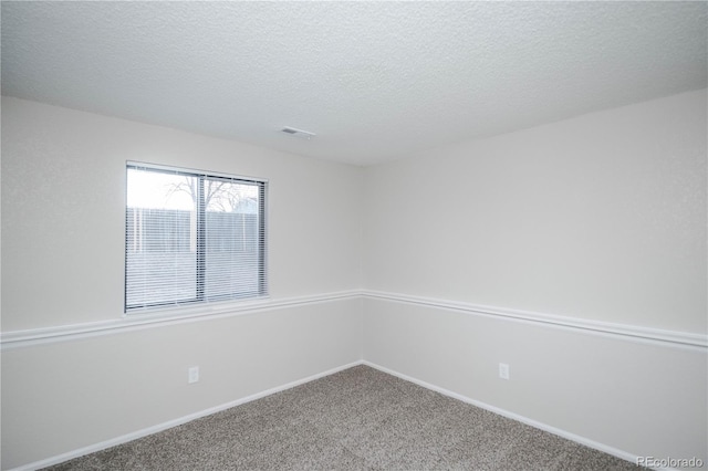 carpeted empty room with a textured ceiling