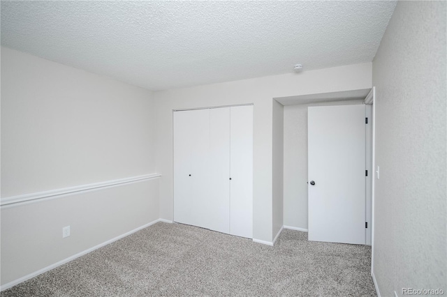 unfurnished bedroom with light colored carpet, a textured ceiling, and a closet