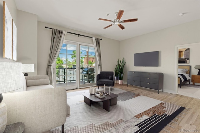 living room with light hardwood / wood-style floors and ceiling fan