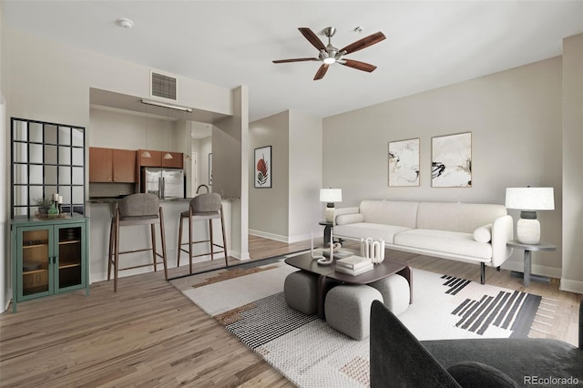 living room featuring ceiling fan and light hardwood / wood-style flooring