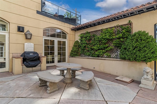 view of patio / terrace with french doors, a grill, and a balcony