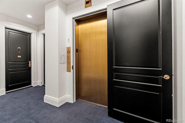 interior space featuring elevator and dark colored carpet