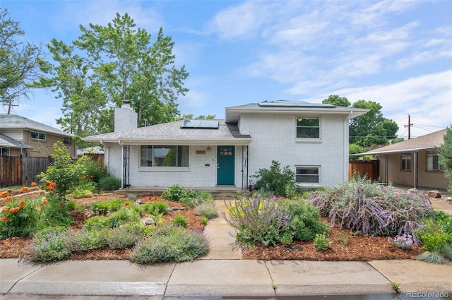 5315 Newland St, Arvada, CO 80002 - split level home with brick siding, solar panels, and a chimney