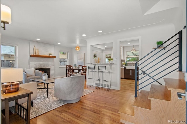 5315 Newland St, Arvada, CO 80002 - living area with wood finished floors, a fireplace, stairs, and recessed lighting