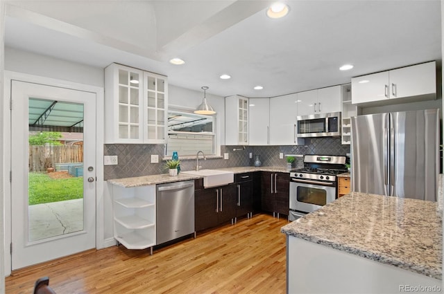 5315 Newland St, Arvada, CO 80002 - kitchen featuring appliances with stainless steel finishes, open shelves, a sink, light wood finished floors, and decorative backsplash