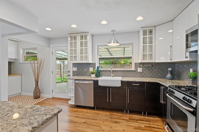 5315 Newland St, Arvada, CO 80002 - kitchen with stainless steel appliances, a sink, white cabinetry, light wood finished floors, and recessed lighting