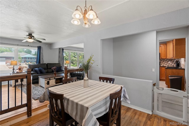 160 Northglenn Dr, Northglenn, CO 80233 - dining space with light wood-type flooring, a chandelier, a textured ceiling, a ceiling fan, and baseboards