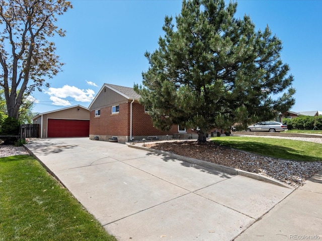 160 Northglenn Dr, Northglenn, CO 80233 - view of side of home with brick siding, a yard, an outbuilding, and concrete driveway