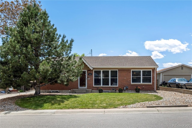 160 Northglenn Dr, Northglenn, CO 80233 - view of front facade with brick siding, a front lawn, entry steps, and a shingled roof