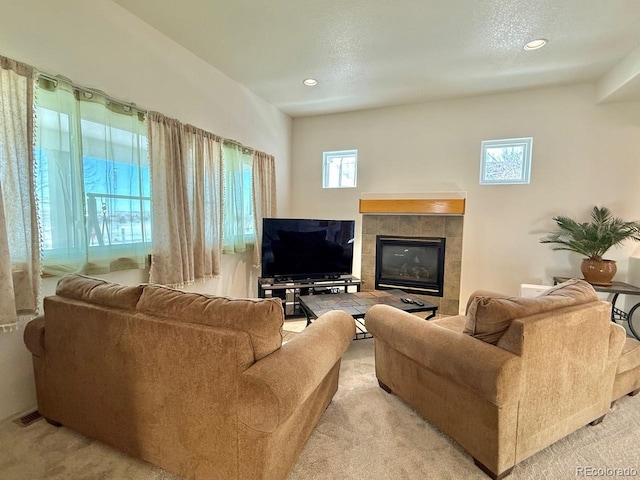 living room featuring a tiled fireplace and light carpet