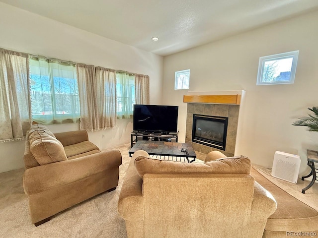 carpeted living room with a healthy amount of sunlight and a tiled fireplace