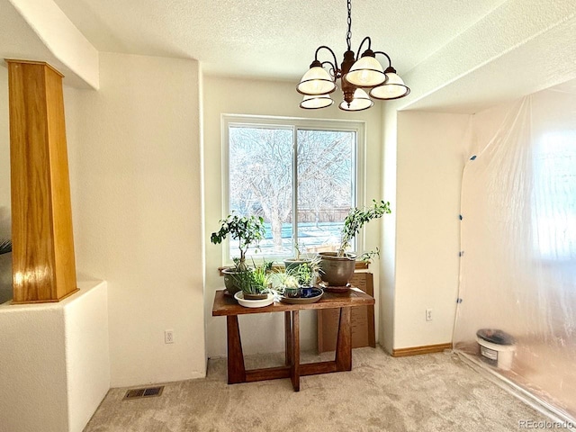 entryway with a notable chandelier and light colored carpet