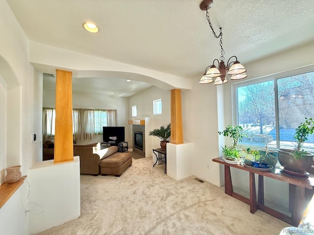 carpeted living room featuring a textured ceiling and a healthy amount of sunlight