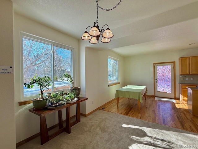 dining area with a chandelier, hardwood / wood-style floors, and a textured ceiling