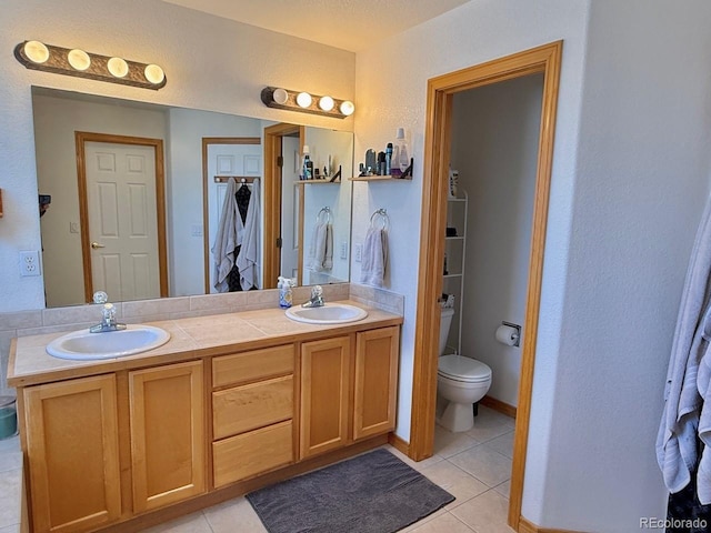 bathroom with vanity, tile patterned floors, and toilet