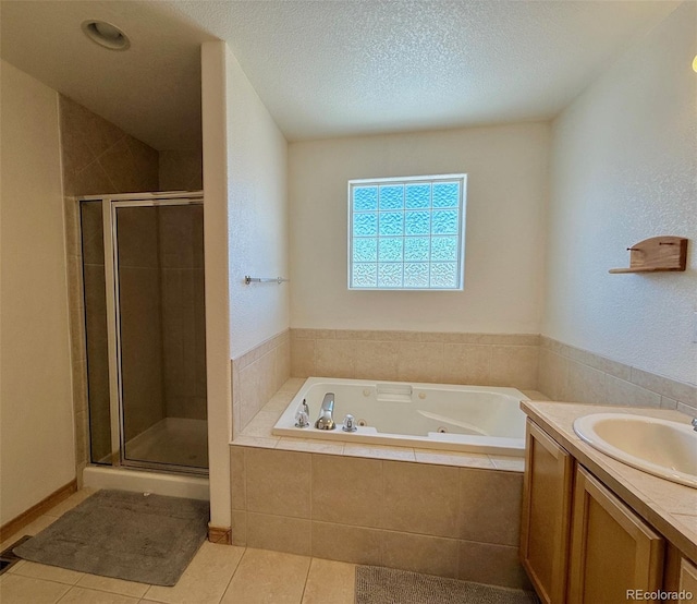 bathroom featuring tile patterned flooring, vanity, separate shower and tub, and a textured ceiling