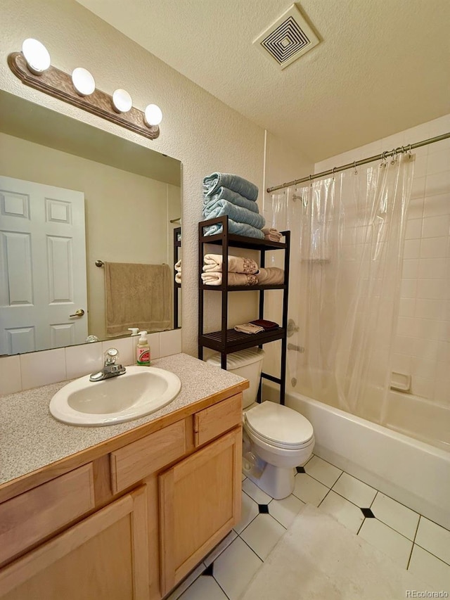 full bathroom featuring shower / bath combo, tile patterned flooring, vanity, a textured ceiling, and toilet