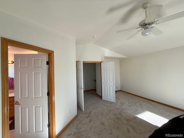 carpeted empty room with vaulted ceiling and ceiling fan