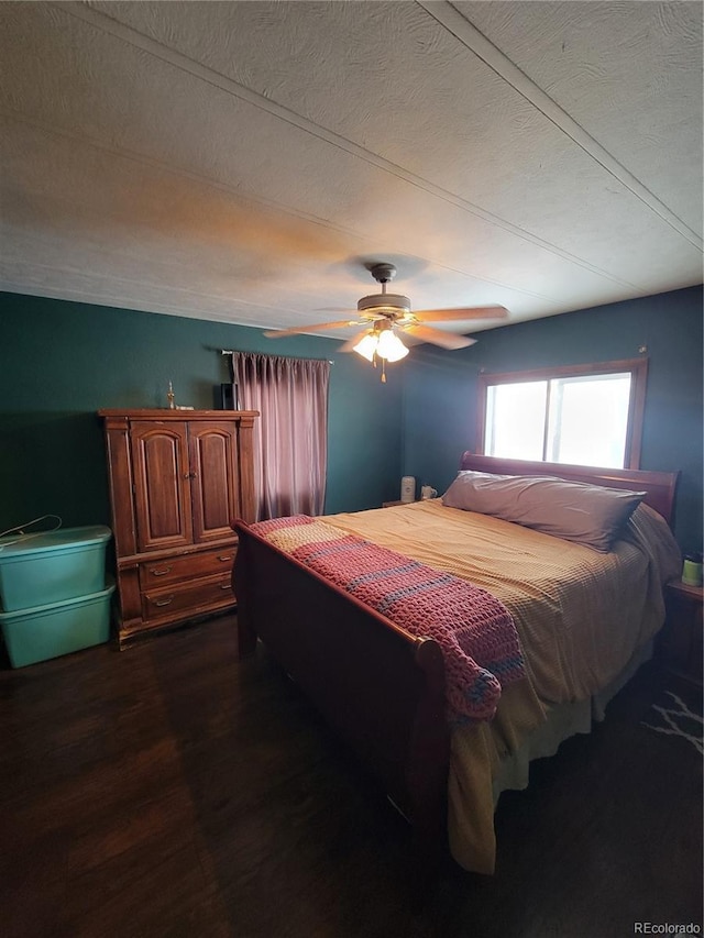 bedroom featuring dark wood-type flooring, ceiling fan, and a textured ceiling