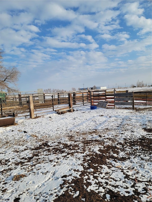 yard covered in snow with a rural view