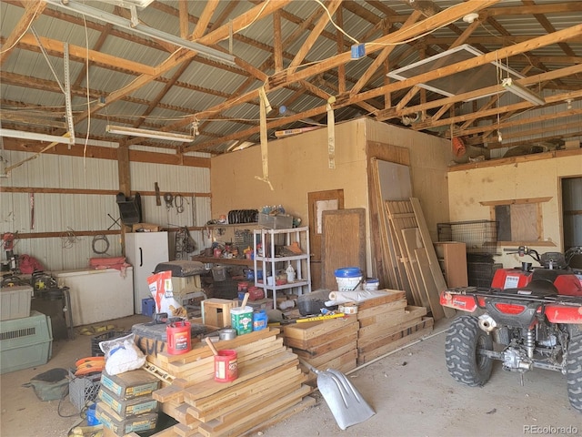 garage with metal wall and freestanding refrigerator