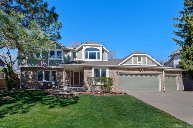 craftsman house with a garage, concrete driveway, brick siding, and a front yard