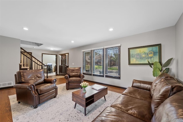 living area featuring visible vents, recessed lighting, stairs, and wood finished floors