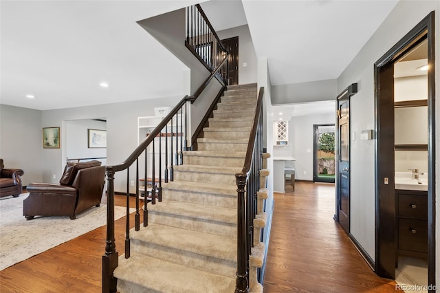 stairs featuring recessed lighting, baseboards, and wood finished floors
