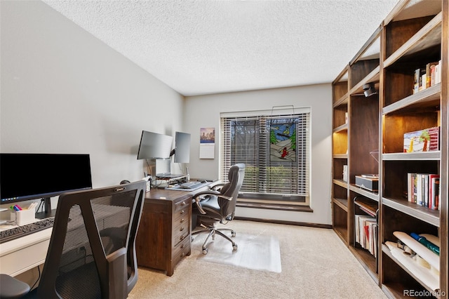 carpeted home office featuring a textured ceiling