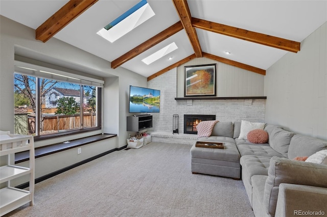 living area with carpet floors, baseboards, lofted ceiling with skylight, and a fireplace