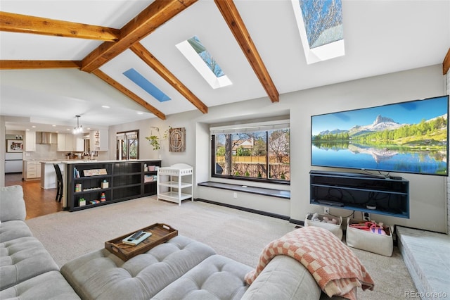 living room with recessed lighting, a notable chandelier, light carpet, and vaulted ceiling with skylight