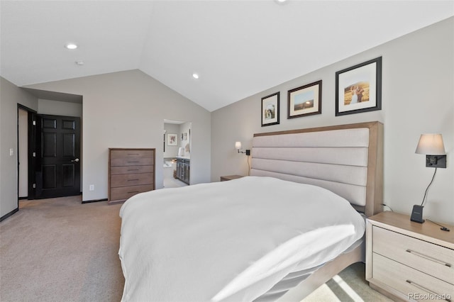 bedroom with recessed lighting, vaulted ceiling, light carpet, and ensuite bath