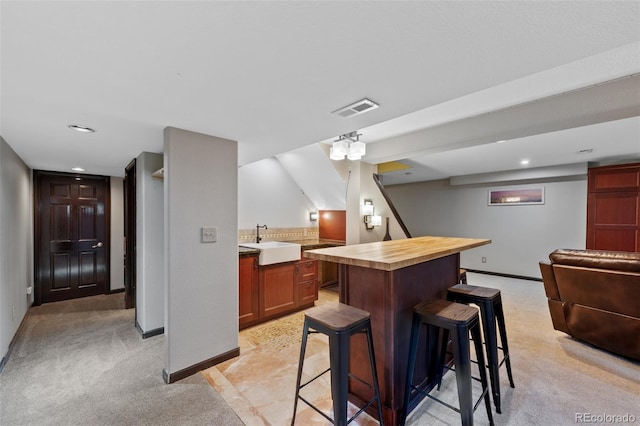 bar with recessed lighting, baseboards, visible vents, and a sink