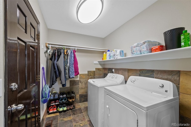laundry area with washer and dryer, laundry area, visible vents, and stone finish floor