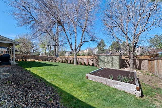 view of yard featuring a storage unit, a fenced backyard, a vegetable garden, and an outdoor structure