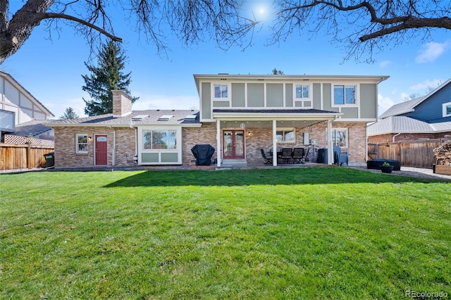back of property with a lawn, a fenced backyard, and a chimney