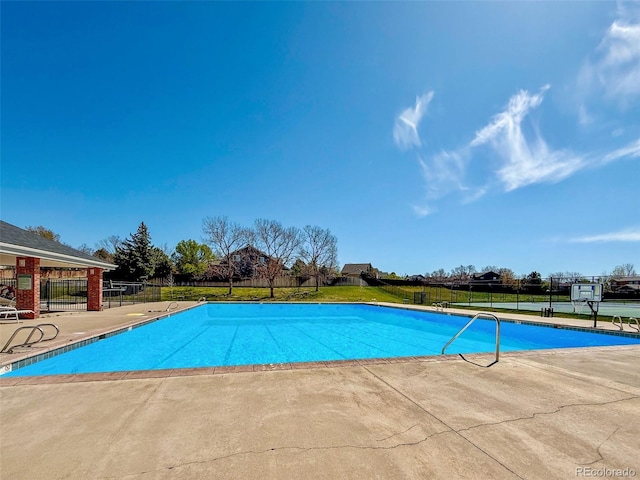 pool with a patio and fence